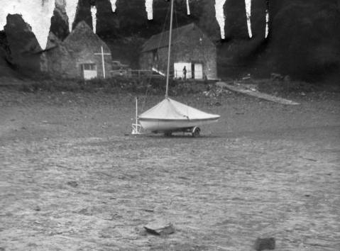 A boat is shown on the dry bank of the reservoir with the derelict building that was later converted to the clubhouse in the background.